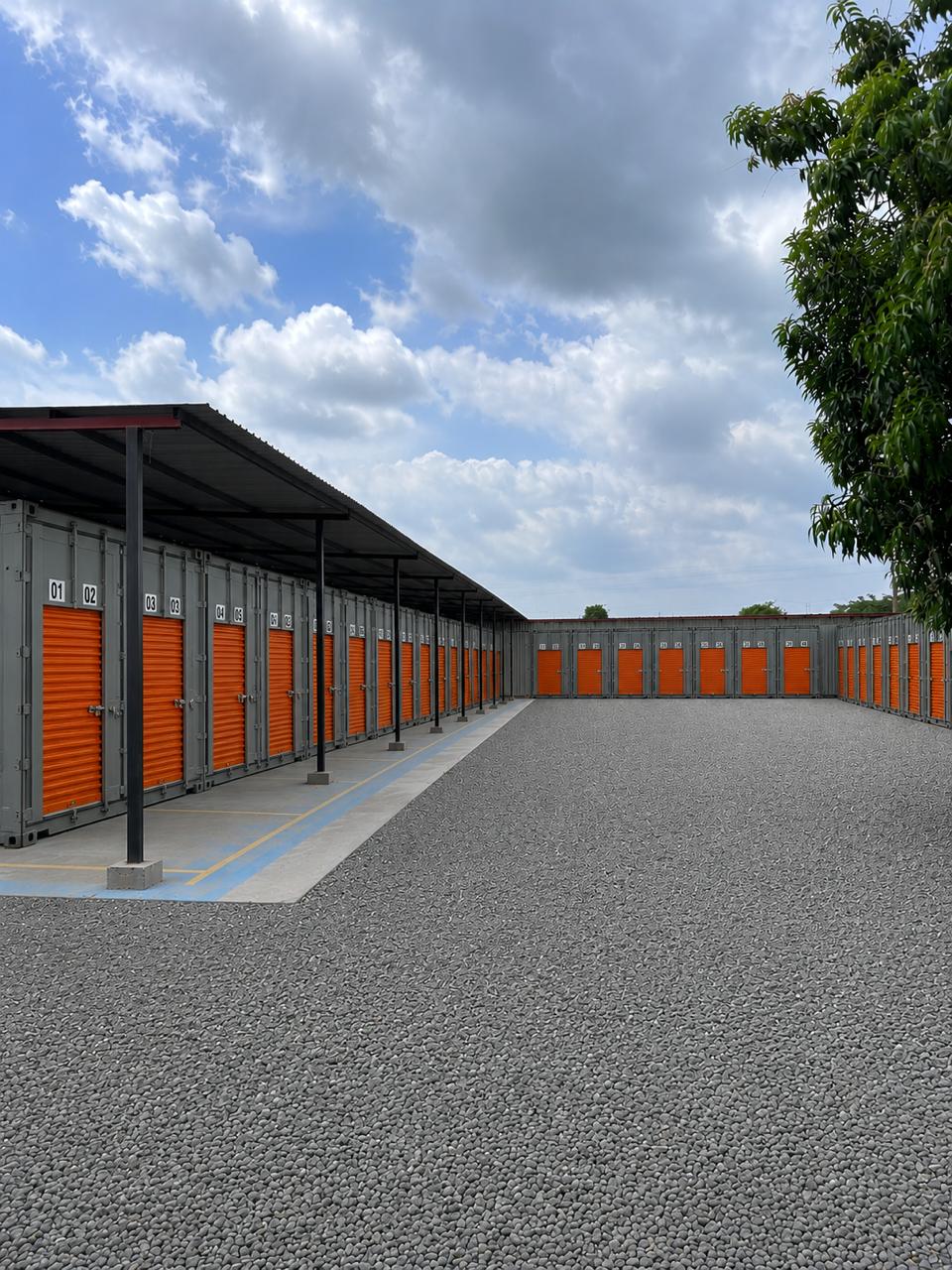 Fila de contenedores grises con puertas naranjas numeradas bajo techo en el parque GUARDA-SAFE